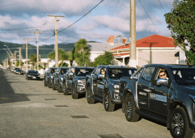 A row of black trucks parked on the side of the road