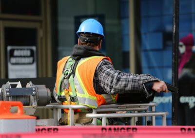 A man in a high vis vest with a blue helmet working on a construction site